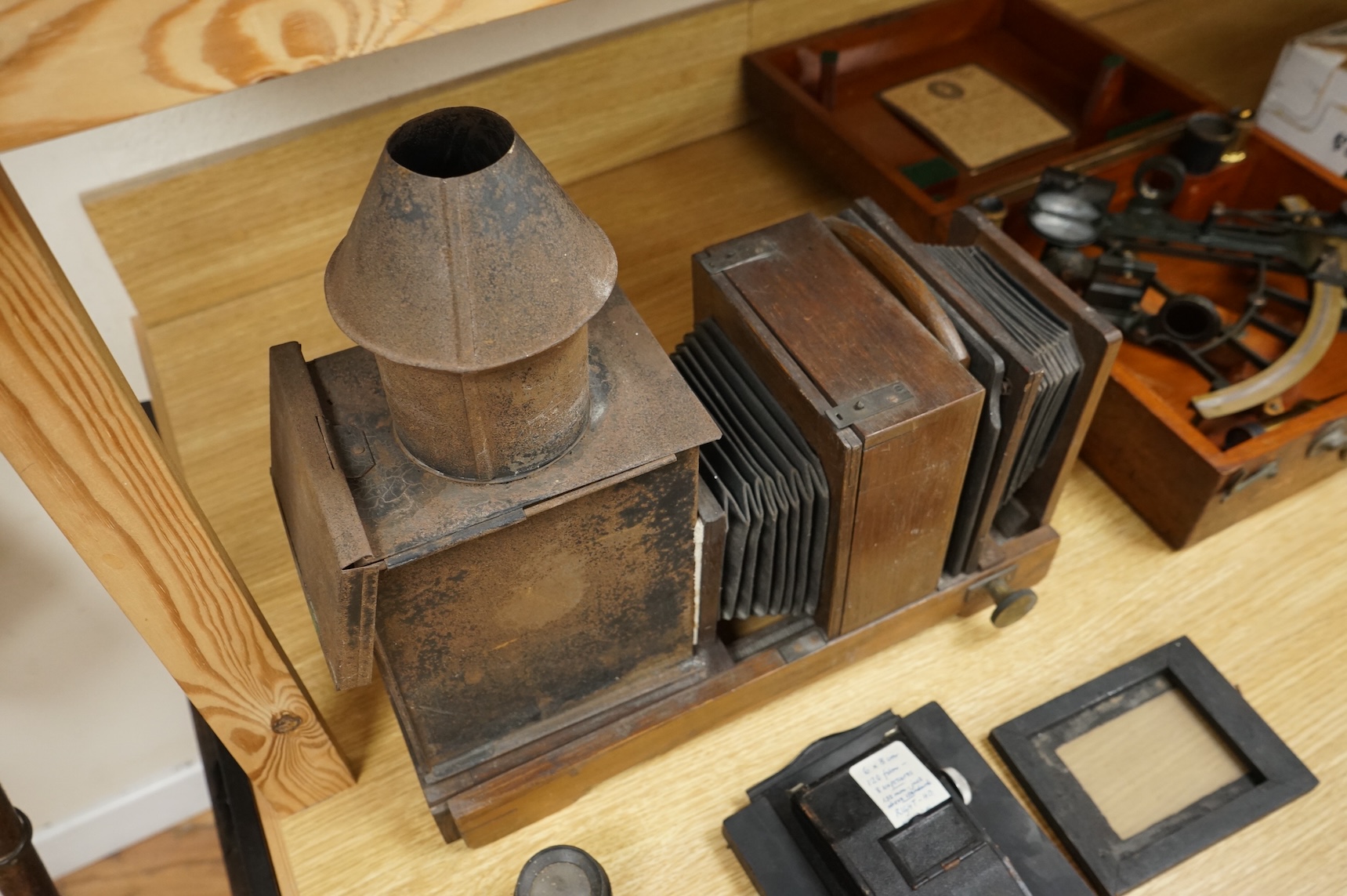 A late 19th century mahogany and tinplate magic lantern style horizontal photograph enlarger, together with some related items.